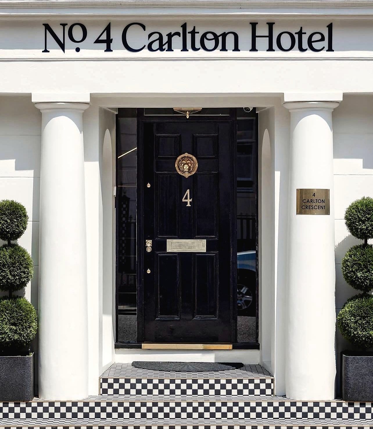 Restored entrance with black door and brass furniture