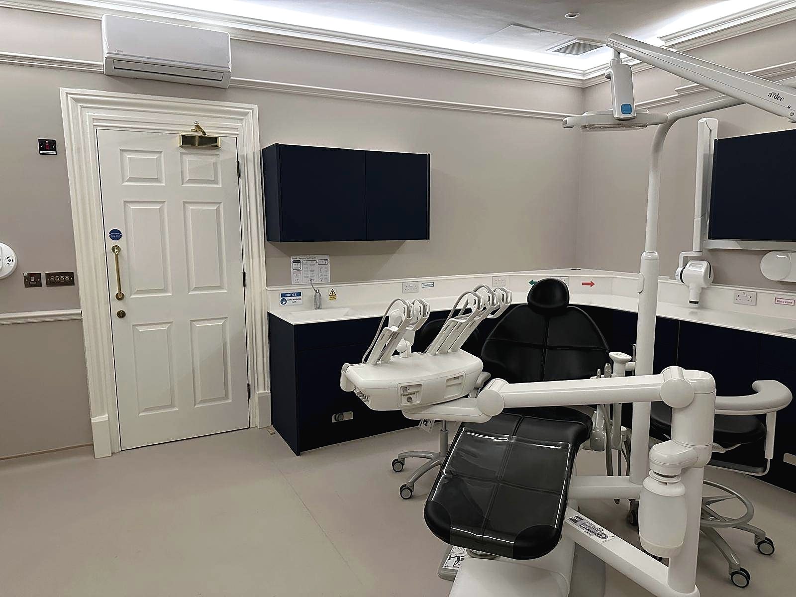 Completed dental surgery with treatment chair, navy cabinetry and original cornice detail