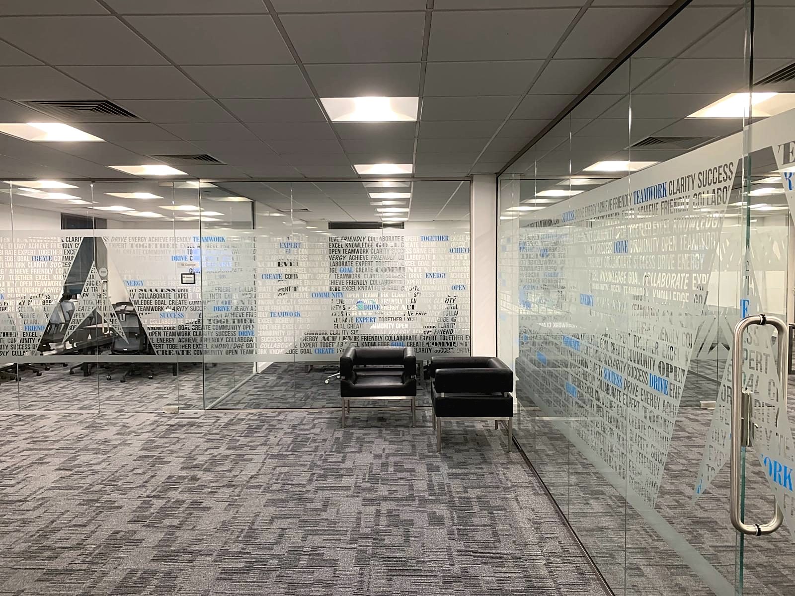 Office meeting room with full height glass partitions and patterned carpet tiles